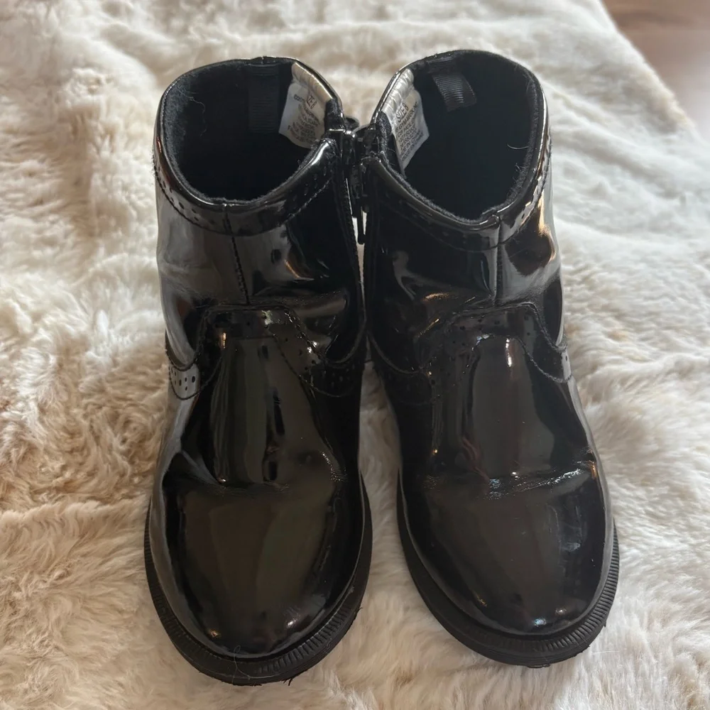 Little girls glossy black boots with bow on the back.